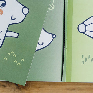 Children's book with cartoon animal illustrations on green pages.