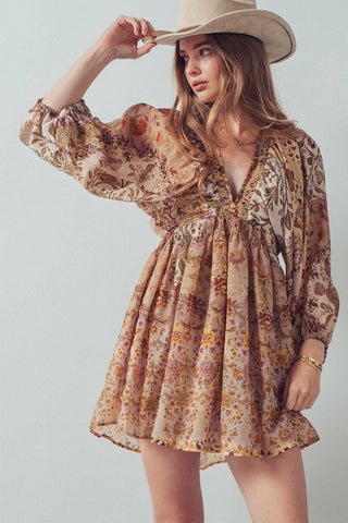 Woman wearing a floral dress and beige hat against a light background