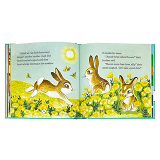 Open book with illustrations of bunnies in a field of flowers