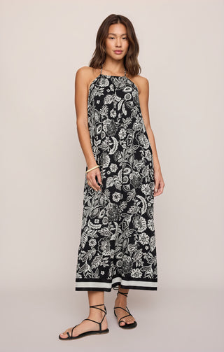Woman wearing a black and white floral dress on a beige background