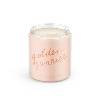 Candle in a pink jar with 'golden sunrise' text on a white background