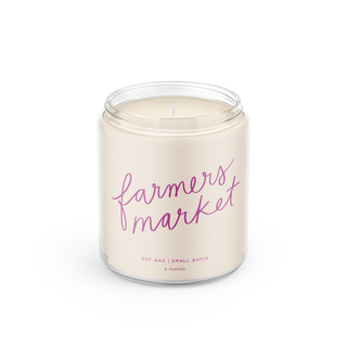 Candle in a jar labeled 'farmers market' on a white background