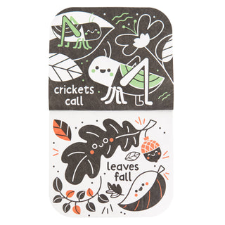 A folded paper card or coaster with rounded corners, featuring autumn-themed illustrations and text. The top half is dark brown with white line art of crickets and leaves, with the words 'crickets call'.