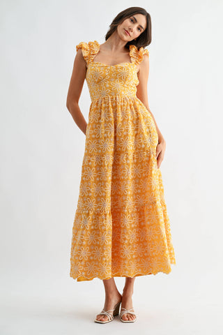 Woman wearing a yellow floral dress on a white background