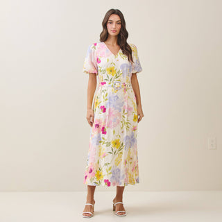 Woman wearing a floral dress against a plain background