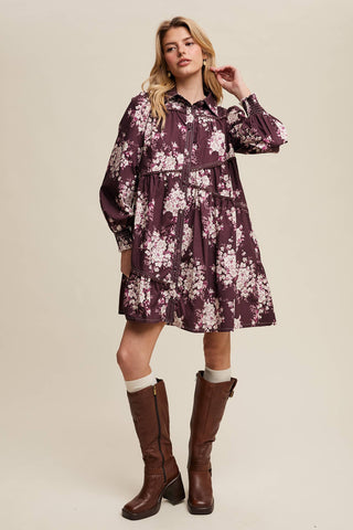 Woman wearing a floral dress with long sleeves and brown knee-high boots on a beige background