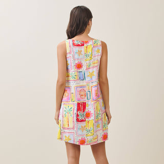 Woman wearing a colorful patterned dress against a plain background