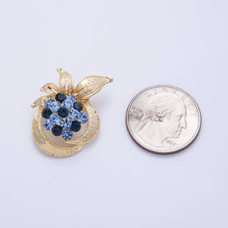 Gold pendant with blue gemstones next to a US quarter on a white background
