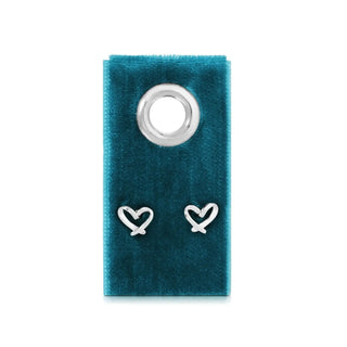 Heart-shaped silver earrings on a blue velvet stand with a white background