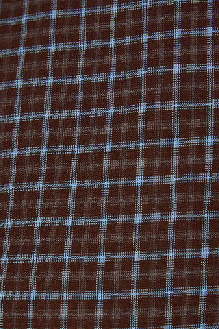 A close-up of a brown fabric with a white grid plaid pattern.