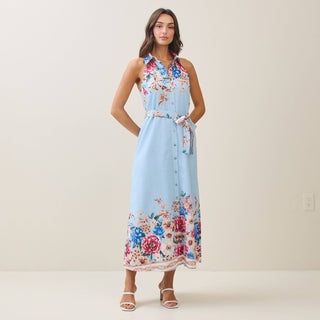 Woman wearing a light blue floral dress against a plain background