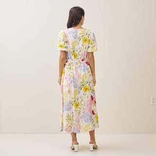 Woman wearing a floral dress against a plain background