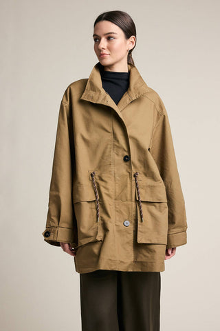 Woman wearing a brown coat against a plain background