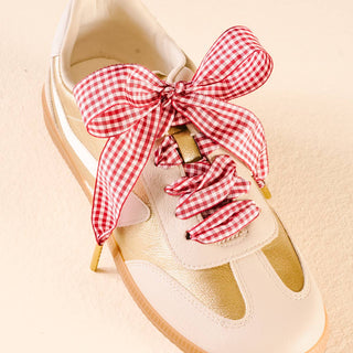 Beige shoe with a red and white checkered bow and matching scrunchie on a beige background