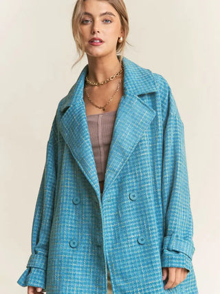 Woman wearing a blue checkered coat against a beige background