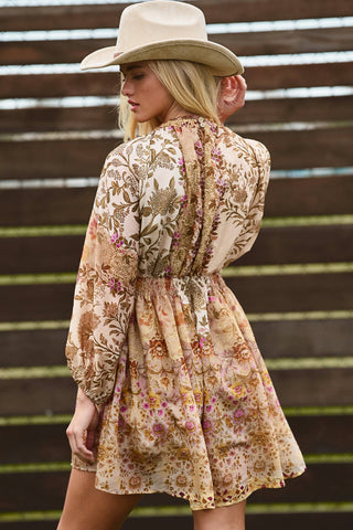 Woman wearing a floral dress and cowboy hat against a wooden background