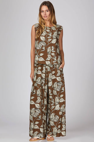 Woman wearing a brown floral jumpsuit on a white background