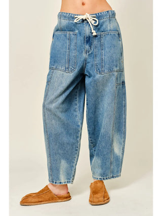 Blue denim baggy pants worn by a person on a plain background