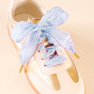 Shoe with blue checkered bow on a beige background