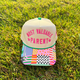 Cap with 'Most Valuable Parent' text on grass