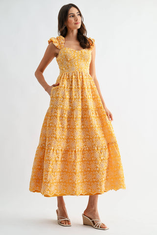 Woman wearing a yellow floral dress on a white background