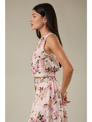 Woman wearing a floral dress against a neutral background