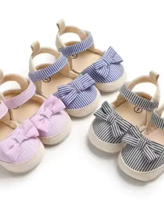 Set of children's sandals with bow details on a white background