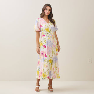 Woman wearing a floral dress against a plain background