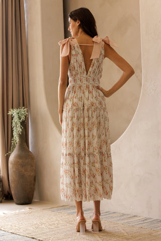 Woman wearing a floral dress in a warm-toned interior setting