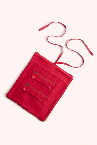 Red jewelry rollwith a strap on a white background