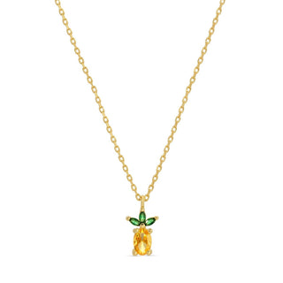 Gold necklace with a pineapple-shaped pendant featuring a yellow gemstone and green accents on a white background.