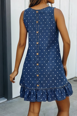 Woman wearing a blue denim dress with white polka dots and ruffled hem.