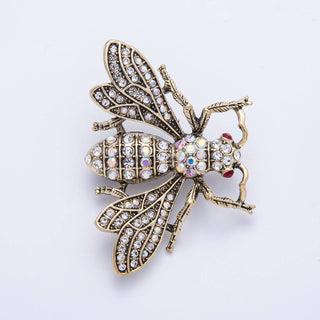 Decorative bee brooch with gemstones on a white background