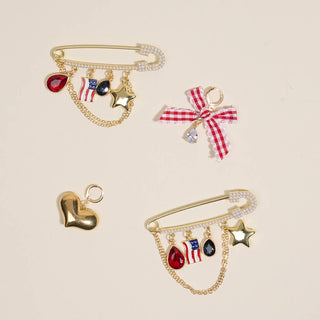 Set of decorative brooches with stars, hearts, and American flag designs on a beige background.