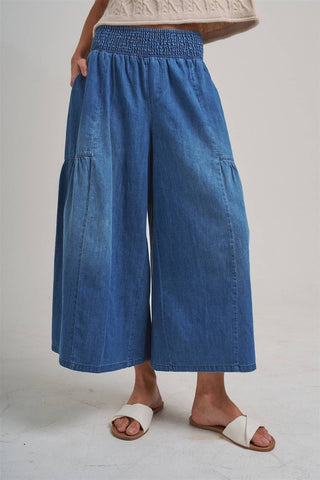 Blue denim wide-leg pants worn by a person on a plain background