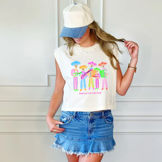 Woman wearing a sleeveless graphic tee and denim skirt with a white background