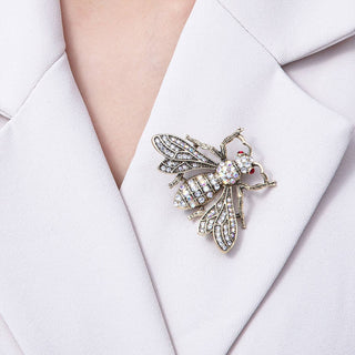 Close-up of a decorative brooch on a white blazer