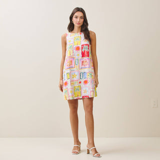 Woman wearing a colorful patterned dress against a plain background