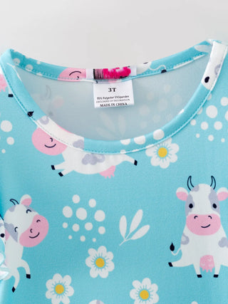 Children's shirt with cow and flower pattern on a blue background
