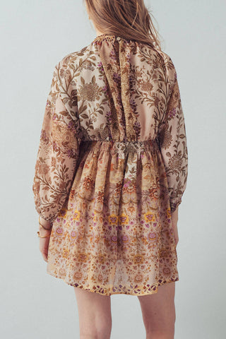 Person wearing a floral dress with long sleeves on a plain background