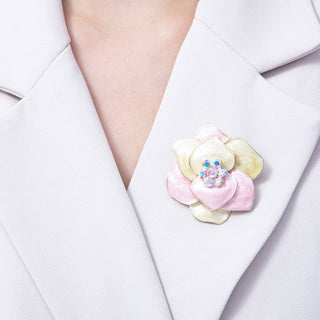 Pastel-colored floral brooch on a white blazer