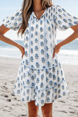 Woman wearing a blue floral dress on a beach