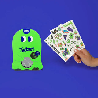 Green packaging of OMY tattoos with a hand holding a sheet of stickers against a blue background