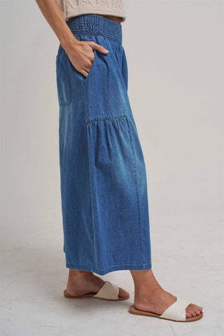 Person wearing blue denim pants on a plain background