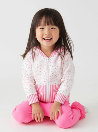 Child wearing a white jacket with pink accents and pink pants on a white background