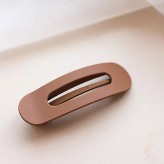 Brown hair clip on a light beige background