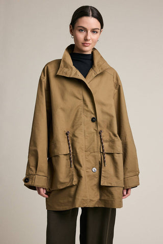 Woman wearing a brown coat on a beige background