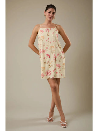 Woman wearing a floral dress against a plain background