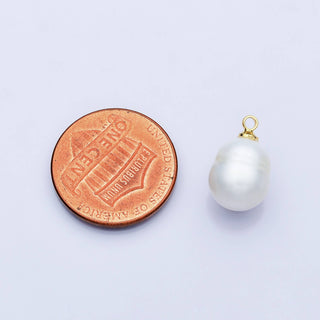 Pearl pendant next to a penny on a light purple background