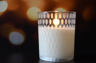 Candle in a glass holder with a blurred bokeh background